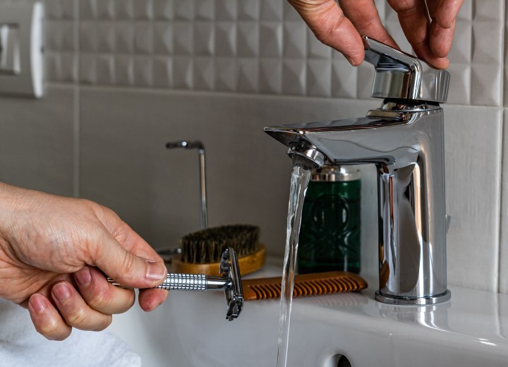 Usare acqua per sciacquare un rasoio manuale