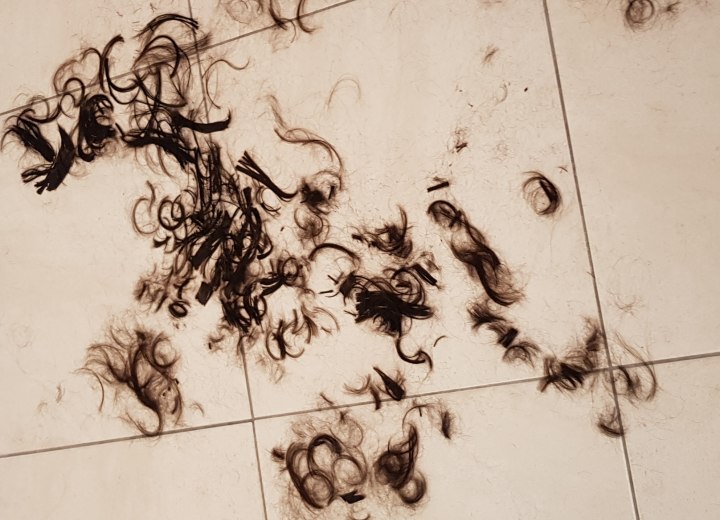 Capelli appena tagliati, stesi sul pavimento