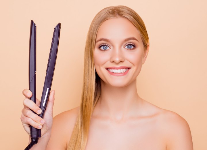 Donna con la piastra per capelli