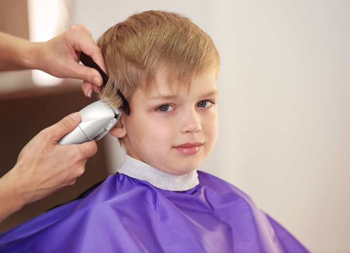 Bambino che si fa tagliare i capelli con il tagliacapelli elettrico
